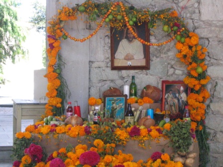 Ofrenda containing favorite items, food, and marigolds for deceased relatives.