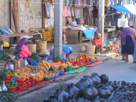 Indigenous women selling produce, pottery, and textiles at the Tlacolula market.